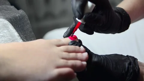 Applying red nail polish to toenails during pedicure 스톡 동영상 344039543