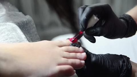 Applying red nail polish to toenails during pedicure Stock Footage 344039552
