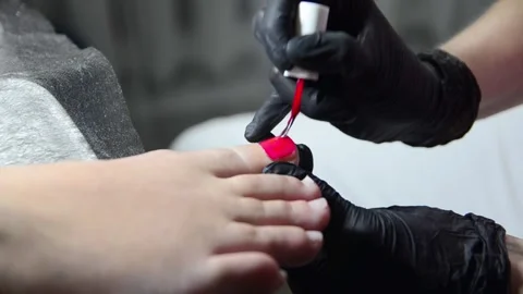 Applying red nail polish to toenails during pedicure Stock Footage 344039554