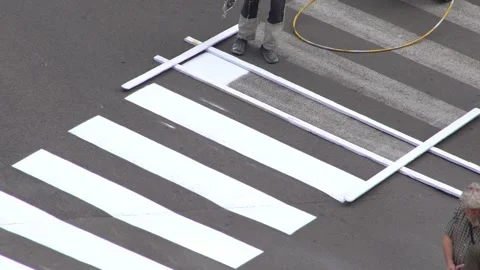 Applying road markings. Paint a pedestrian crossing with white paint. Stock Footage 321047846