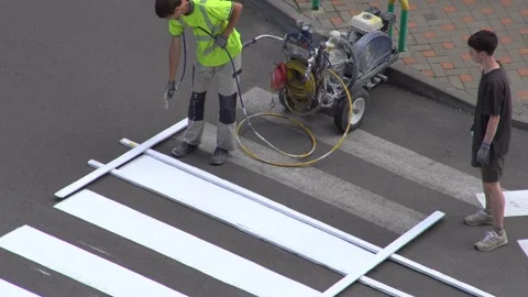 Applying road markings. Paint a pedestrian crossing with white paint. Stock Footage 321451178