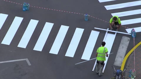 Applying road markings. Paint a pedestrian crossing with white paint. Stock Footage 329966773