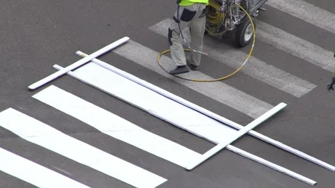 Applying road markings. Paint a pedestrian crossing with white paint. Stock Footage 329966803