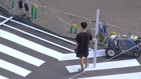 Applying road markings. Paint a pedestrian crossing with white paint. Top view Stock Footage 329966821