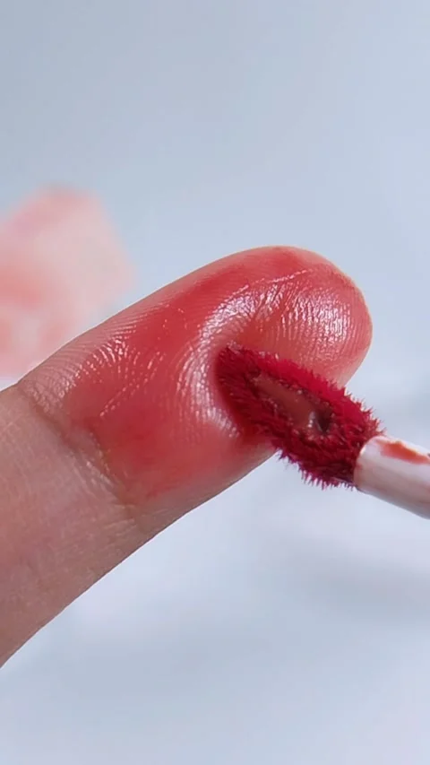 Applying rosy red color on fingertip using a brush. Extreme vertical close .. Video stock 340970989