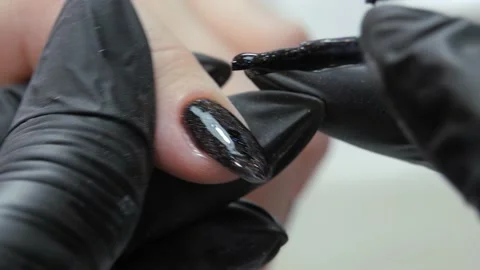 Applying a second layer of black lacquer to the varnished surface of the nail. Stock Footage 196121636