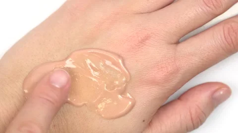 Applying skin foundation or glow primer on skin of hand, close up. Decorati.. Stock Footage 294172829