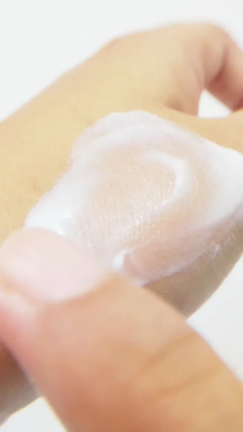 Applying soft white cream slowly to back of hand. Gentle moisturizing texture Vídeo Stock 335388493