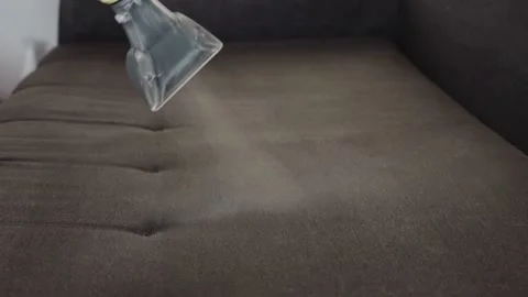 Applying a special cleaning solution to clean stains and dirt on upholstery of Stock Footage 253469891