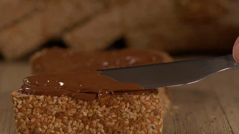 Applying Spread on Multi Grain Loaf Of Bread with Seeds 스톡 동영상 130152709