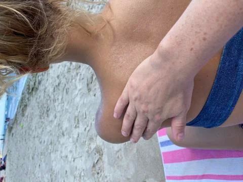 Applying sunscreen on the beach, close up Stock Photos