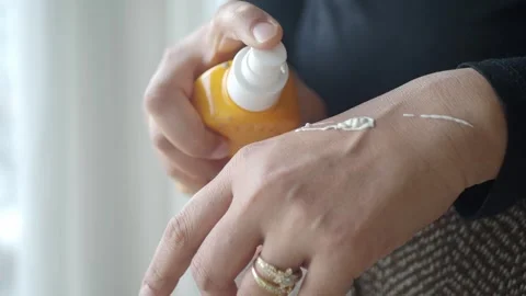 Applying sunscreen cream on hand Stock Footage 344514690