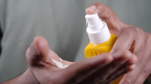 Applying sunscreen on hands during daytime 库存影片 337143339