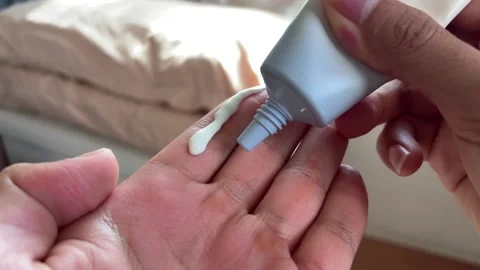Applying sunscreen using two finger rule Stock Footage 345294334
