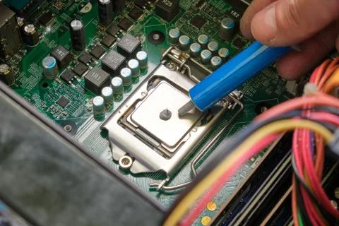 Applying thermal gel to a computer CPU laced in its motherboard socket. Foto stock