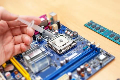 Applying thermal paste to a computer processor. Processor installation concep Stock Photos