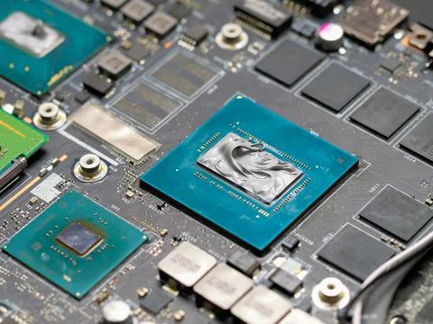 Applying thermal paste to a laptop processor, cooling computer components. Stock Photos