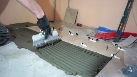 Applying thinset mortar on a tile. Apply the adhesive, closeup. Video stock 150962928