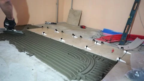 Applying thinset mortar on a tile. Apply the adhesive, closeup. Video stock 152241578