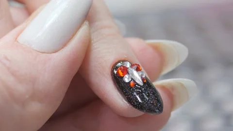 Applying a three-dimensional pattern with rhinestones and broths on the nail. Stock Footage 172167778