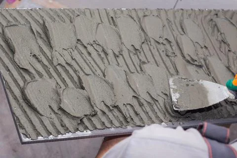 Applying tile adhesive on tile Stock Photos
