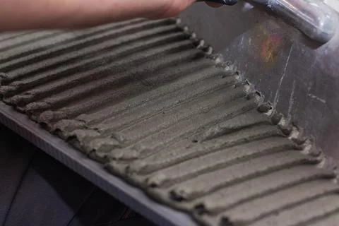Applying tile adhesive on tile Stock Photos