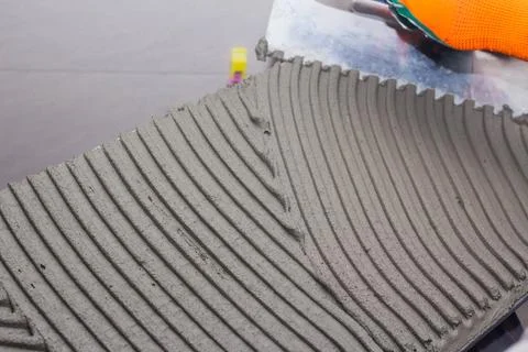 Applying tile adhesive on tile Stock Photos