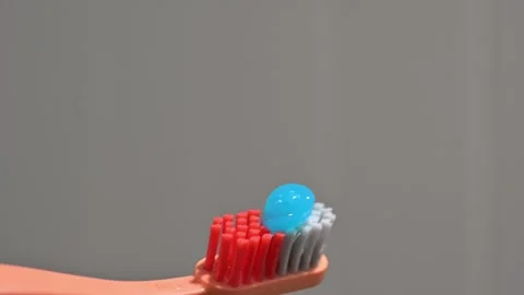 Applying Toothpaste to Orange Toothbrush – Oral Hygiene Close-Up Stock Footage 345204093