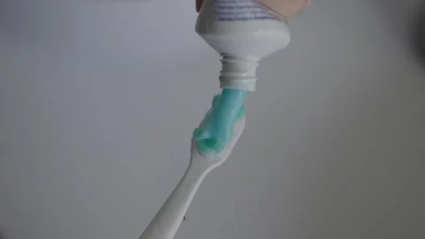 Applying toothpaste onto toothbrush close up in bathroom 스톡 동영상 331049657