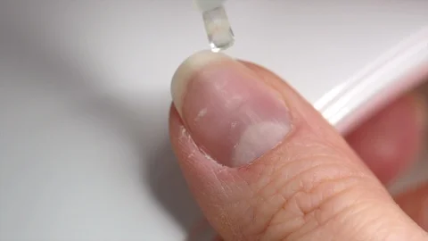 Applying transparent base coat soak-off gel nail polish on natural nails Stock Footage 122129893