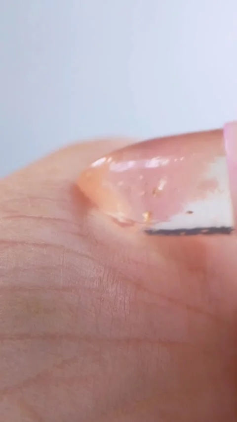 Applying transparent pink lip balm on palm. Close up view on white background Stock Footage 339061928