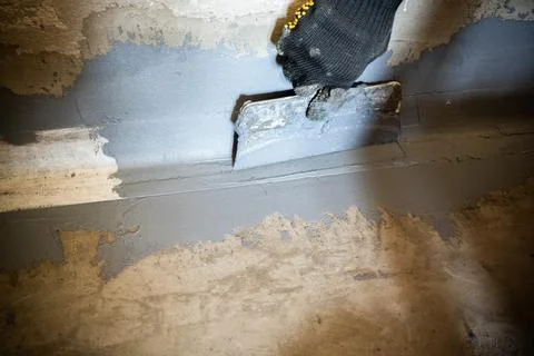 Applying a waterproofing tape to the joint between the wall and the floor Stock Photos