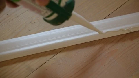 Applying white glue to ceiling molding Stock Footage 76040224