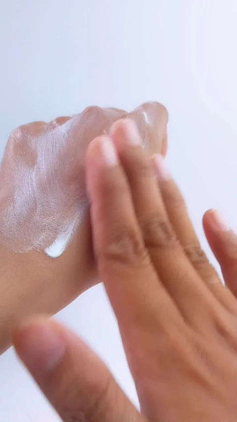 Applying whitening cream thoroughly to left hand. Skin care concept. Anti UV Stock Footage 335388841