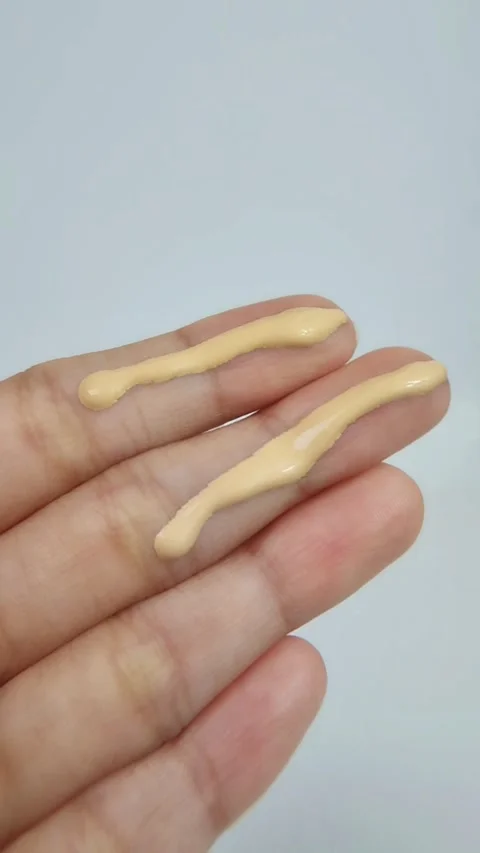 Applying yellow cream to fingertips. Vertical close-up view Vídeos de archivo 329679404