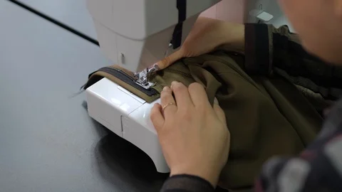 Applying the zipper to a pair of pants. Creating the costume design Stock Footage 126726810