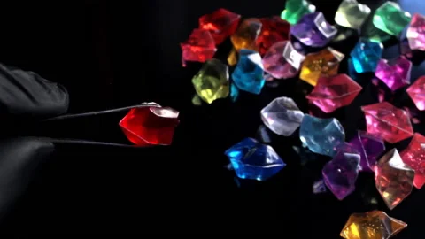 An appraiser in a pawnshop holds a red ruby-like gemstone with tweezers Stock Footage 195264372