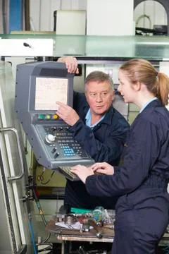 Apprentice And Engineer Using Computer Controlled Cutting Machine 스톡 사진