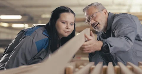 Apprentice and instructor examine wood panel in workshop Stock Footage 254678074