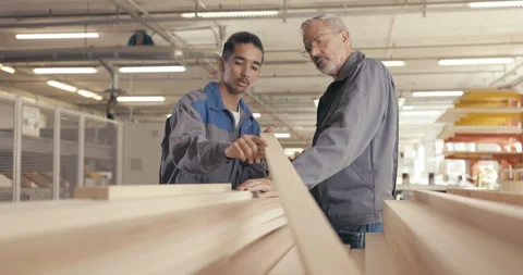 Apprentice and instructor examine wood panel in workshop Stock Footage 254678826