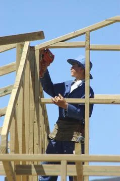 Apprentice builder using nail gun on building site Stock Photos
