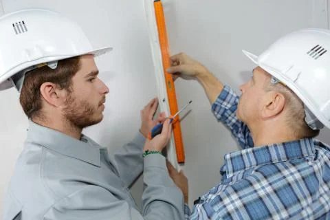 Apprentice construction worker leanring with experienced tradesman Stock Photos
