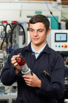 Apprentice Engineer Checking Component In Factory Stock Photos