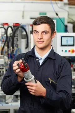 Apprentice Engineer Checking Component In Factory 库存照片