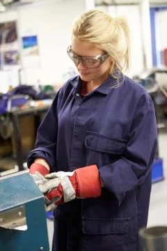 Apprentice engineer working on factory floor Foto stock