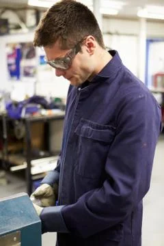 Apprentice engineer working on factory floor Stock Photos