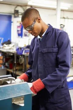 Apprentice engineer working on factory floor Stock Photos