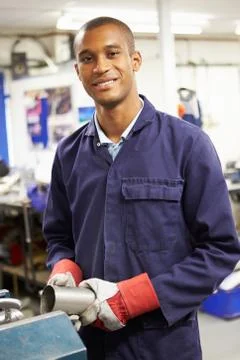 Apprentice engineer working on factory floor Stock Photos