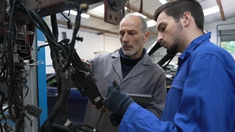 Apprentice with instructor working on vehicle Stock Footage 123162778