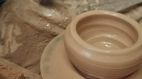 Apprentice learning clay pottery on ancient kick operated revolving wheel Stock Footage 171242844